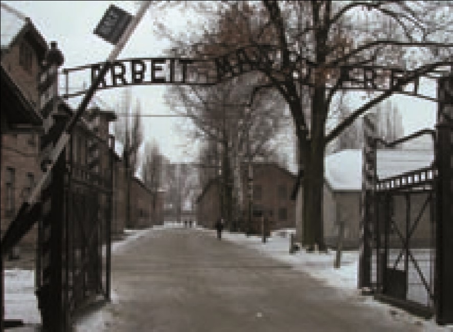 The gates of Auschwitz I and the original brick barrack buildings of the first site.jpg