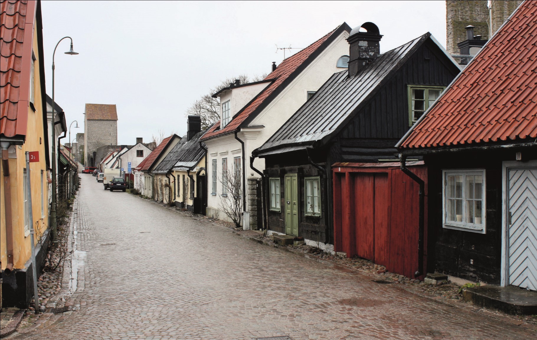 Wooden buildings next to the city walls at Visby.jpg