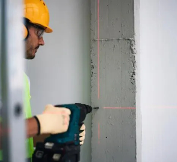 Construction worker drills into a wall 350. jpeg.jpg