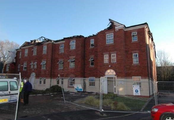 Block of flats showing the area of fire origin and damage to roof level.jpg